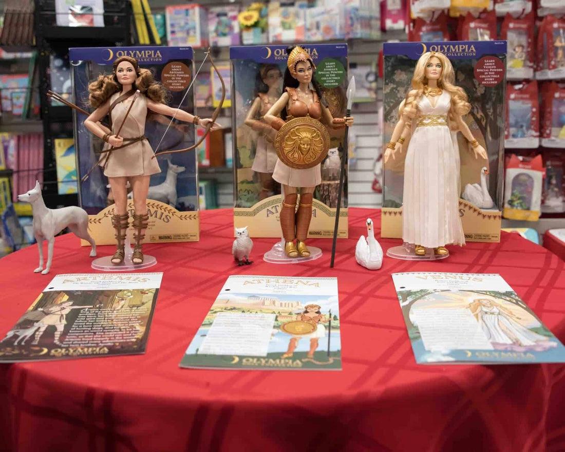 The Olympia Dolls with activity story books on red table cloth