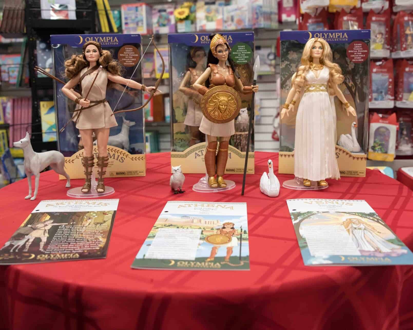 The Olympia Dolls with activity story books on red table cloth
