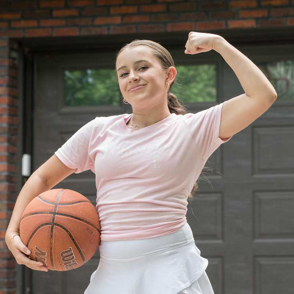 Girl with basketball flexing muscle