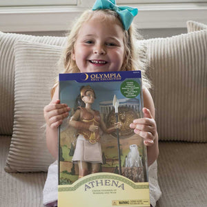 Young girl holding an Athena doll packaging with 'Olympia Doll' branding